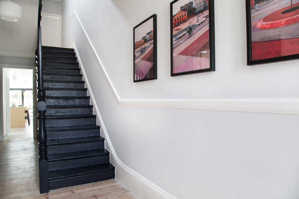 Restored Victorian pine floorboards with contrasting black staircase