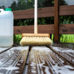 Brush and plastic canister with detergent on a wooden board, woo
