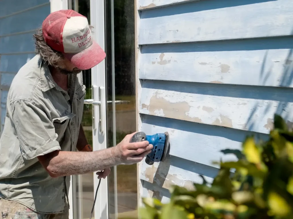Sanding to lose flaking paint and key the surface for new coats.