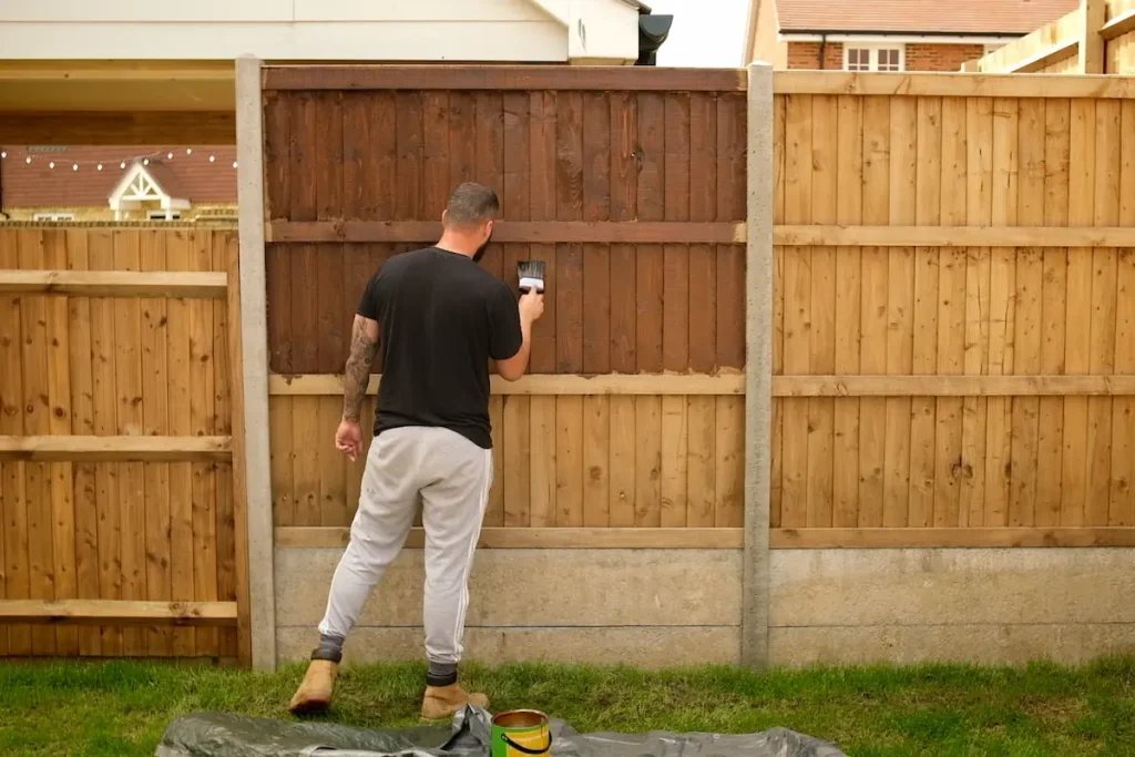Applying Sadolin Classic Burma Teak woodstain to a wooden garden fence