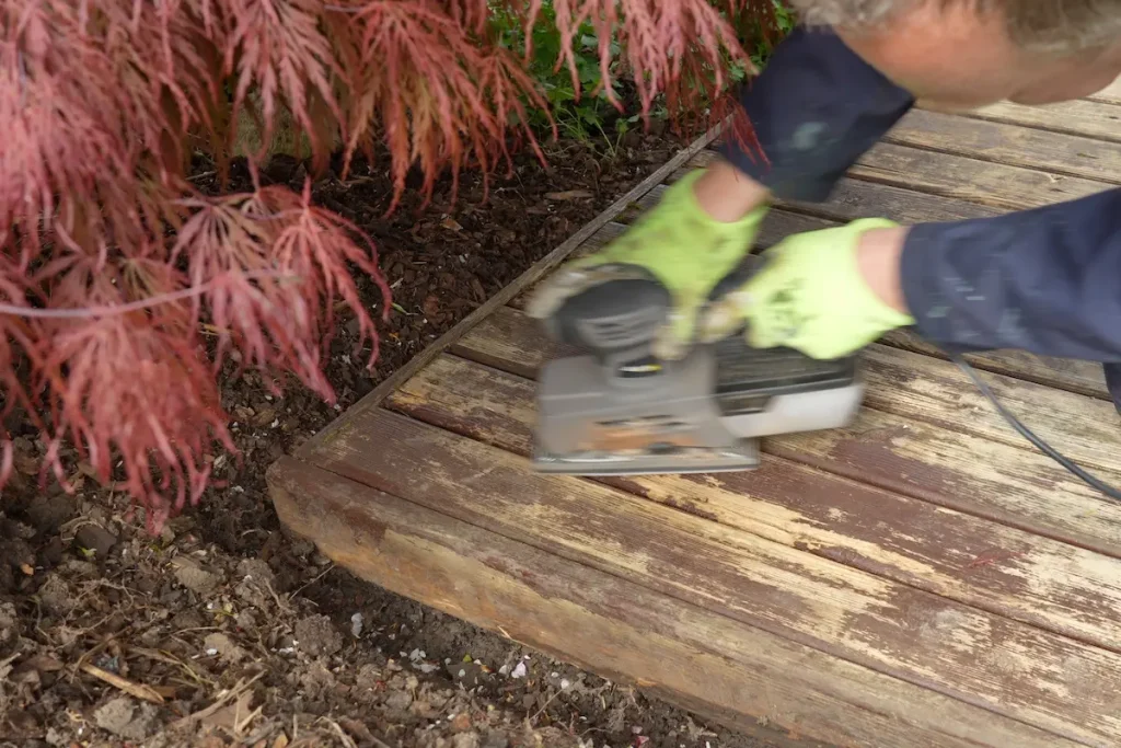 Sanding loose and flaking paint from wooden decking