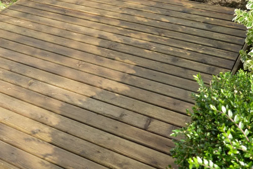 Applying clear wood preserver to prepared decking boards